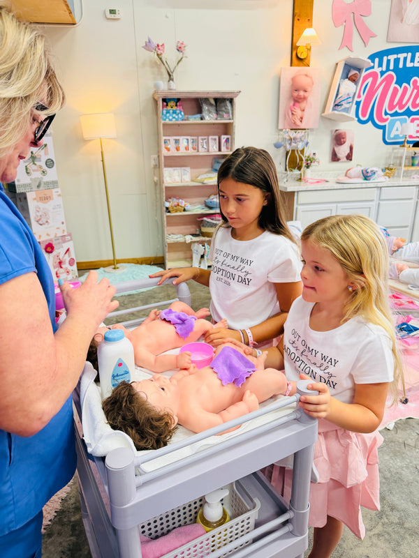 Little Mamas Nursery staff and children caring for and bathing silicone baby dolls